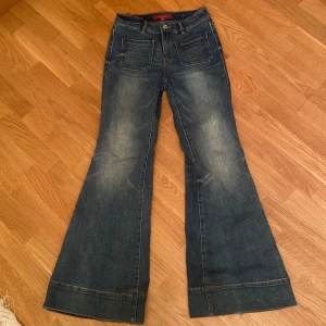 Blå jeans från Miss Sixty - Snygga blå jeans från Miss Sixty med bootcut-stil. Ger en 70-tals vibe. Köptes för ca 2700kr. Använd få tal gånger och är endast lite sliten längst ner men inget märkbart. Pris kan diskuteras