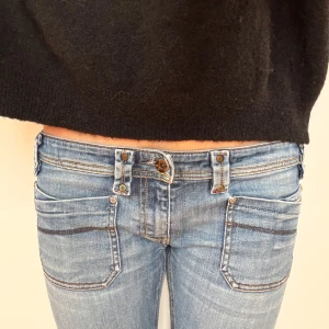 Lågmidjade utsvängda diesel jeans - Utsvängda jeans i ljusblå färg med dragkedjor på bakfickan från diesel. W30 L34💞Midjemått är 40.5cm. Jag är 175cm på bilden. Hör av dig vid frågor💗 