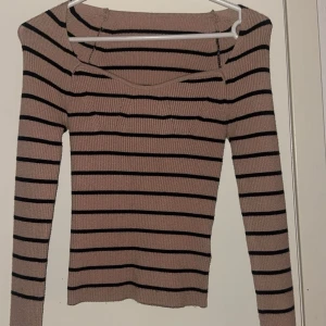 Beige och svart randig ribbad tröja - Snygg beige tröja med svarta ränder och ribbad design. Tröjan har långa ärmar och en stilren look som passar perfekt till vardags. Perfekt för dig som gillar en klassisk stil med en modern touch. Storlek Xs men kan även användes som xxs 💗💗