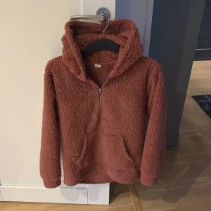 Rosa/röd  fleece hoodie - Mysig rosa/röd fleece hoodie med dragkedja och huva. Perfekt för kyliga dagar med sin fluffiga och varma design. Har en praktisk ficka framtill. Köpt för 500kr!💓💓