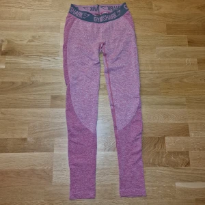 Rosa leggings från Gymshark - Snygga rosa leggings från Gymshark med en bred resår i midjan. Perfekta för träning med sin tighta passform och bekväma material. 