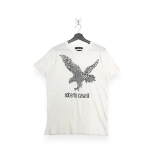 Roberto Cavali tshirt - Tishan är vit med en svart tryck, skick 7/10 och nypris ligger runt 2500 där emot så tillverkas denna tishan inte längre . Kom jätte gärna med prisförslag 