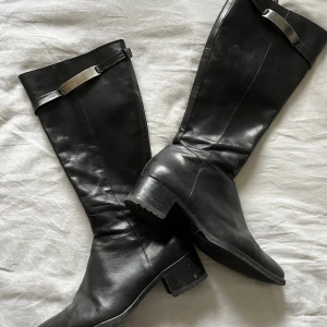 Höga svarta boots läder  - Super snygga höga svarta boots i läder med metall detalj och spetsig tå. Super fint skick 