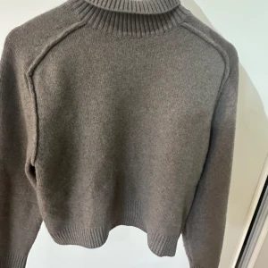 Gråbrun polotröja - Säljer denna grå/bruna stickade tröja med krage. Den är jättemjuk och andvänd väldigt få gånger, så den är inte nopprig 💗 passar till de flesta kläder och sticks inte alls:)