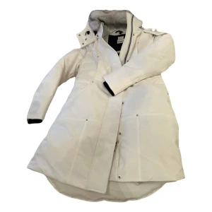Vit parkajacka från Moose Knuckles - Säljer en stilren vit parkajacka från Moose Knuckles med pälskantad huva och dragkedja. Jackan har långa ärmar och flera praktiska fickor. Perfekt för kalla vinterdagar. 🧥❄️