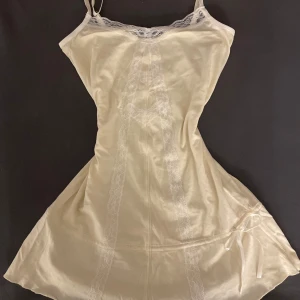Beige coquette nattklänning  - Vintage beige kort klänning, med smala axelband och vackra spetsdetaljer längs med framsidan och halsringen. Går att mötas istället för frakt, skriv ifall du skulle ha någon fråga 😊