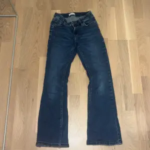 Säljer ett par snygga mörkblå bootcut jeans i bra skick. Jeansen har en bekväm passform och är tillverkade i slitstarkt denim. Perfekta för höst och vår!