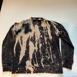 Svart och beige sweatshirt från Nike - Cool och unik svart och beige sweatshirt från Nike med ett abstrakt mönster. Tröjan har långa ärmar och en avslappnad passform, perfekt för både vardag och chill. Den är i bra skick och redo för nya äventyr. Passar perfekt till jeans eller joggers!