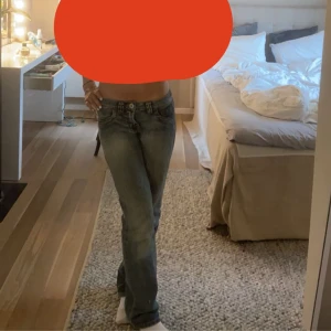 Blå jeans med broderad detalj - Säljer ett par snygga blå jeans med rosa broderad text på bakfickan. Väldigt Lågmidjade, tryck på köp nu, har ni frågor är det bara att skriva till mig! 🥰