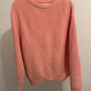 Rosa stickad tröja från Ellos - Mysig rosa stickad tröja från Ellos i storlek 38/40. Perfekt för kyliga dagar med sin varma och bekväma passform. Tröjan har en enkel design med rund hals och långa ärmar. Ett måste för höst- och vintergarderoben! 🍂