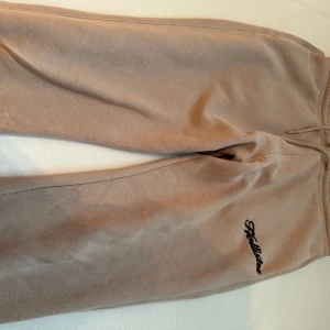 Beige hoodie och mjukisbyxor från Hollister - Säljer en supermjuk och bekväm beige hoodie från Hollister. Perfekt för mysiga dagar eller en avslappnad stil. Den har en klassisk känguruficka och justerbar huva med snören. Hollister-loggan är snyggt broderad på bröstet. Passar perfekt till höst och vinter!