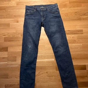 Blå jeans från J.Lindeberg - Säljer ett par snygga blå jeans från J.Lindeberg i modellen Jay. De har en midwaist passform och är i bra skick. litet hål vid knät