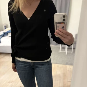 Svart omlottopp med knytning  - Säljer en fin tröja med en omlottknytning!