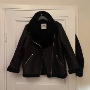 Svart skinnjacka från ZARA - Säljer en snygg svart skinnjacka från ZARA med mjukt foder och dragkedja. Jackan har långa ärmar och stilrena detaljer som ger en cool look. Perfekt för höst och vinter! 🖤