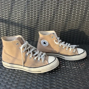 Beige höga sneakers från Converse - Hej, jag säljer nu ett par beiga unisex Converse skor. Skorna är sparsamt använda och i väldigt bra skick!! Skorna är i storlek 42,5. Bara att skriva om du har någon fundering kring skorna😊