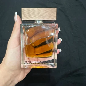 Parfym från Dolce & Gabbana - Säljer en lyxig parfym från Dolce & Gabbana. Flaskan är elegant med en fyrkantig form och en stilren träfärgad kork. Doften är varm och fyllig, perfekt för speciella tillfällen. Flaskan är nästan full och redo att användas. Passa på att köpa denna exklusiva doft!