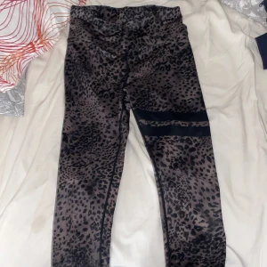 Leopardmönstrade leggings från Stronger - Säljer ett par snygga leopardmönstrade leggings från Stronger i storlek small. De är gjorda av 85% återvunnen polyester och 15% elastan, vilket gör dem både bekväma och miljövänliga. Perfekta för träning eller en avslappnad dag. 🐆