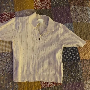Beige stickad pikétröja - Säljer en superfin beige stickad pikétröja med korta ärmar och knappar framtill. Tröjan har ett diskret mönster som ger den en unik touch. Den är i storlek S och är från monki. Perfekt för vår och sommar! 🧶
