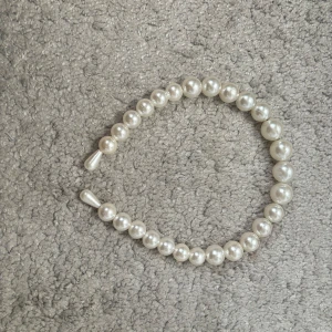 Pärlarmband i vitt - Snyggt och klassiskt pärlarmband med vita pärlor. Perfekt för att ge en elegant touch till vilken outfit som helst. Armbandet är elastiskt och passar de flesta handleder. Perfekt för både vardag och fest!