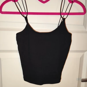 Svart ribbad linnetopp - Snygg svart ribbad linnetopp från 157 i storlek XS/S. Den har smala axelband och en enkel design som passar perfekt till både vardag och fest. Toppen är i bra skick och superbekväm att bära. Perfekt för sommardagar eller som ett lager under en jacka.