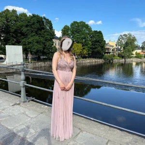 Balklänning - Petite - Märke: Beauut Petite Ordinarie pris: ca 1700kr Säljs inte längre.  Endast använd en gång. Färg: Rosa/Lila med paljetter  Storlek: 34 Petite - Passar perfekt med höga klackar för mig som är 157cm.