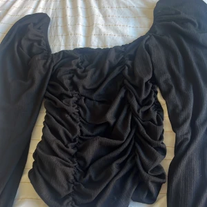 Topp  - En jättefin svart topp från Nelly, i storlek L men skulle även passa för er som har storlek M 