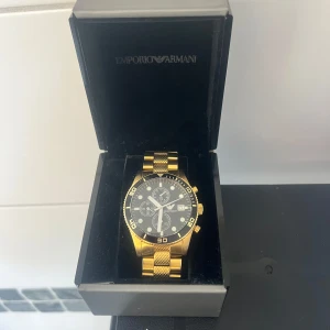 Emporio Armani klocka - Tappat lite färg på baksidan. Säljs i använt skick.  Batteriet på klockan är slut. 