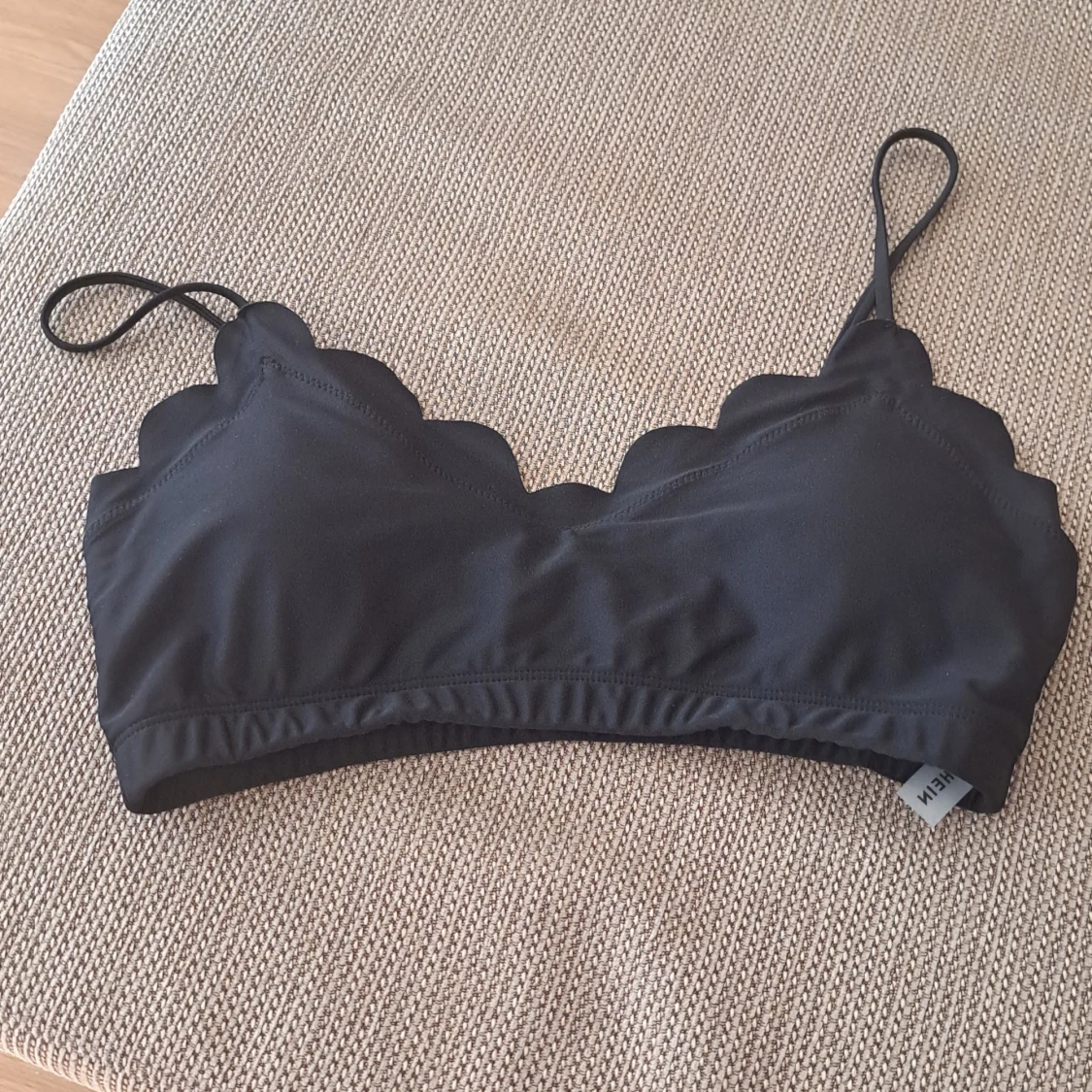 Svart bikiniöverdel med volangdetaljer