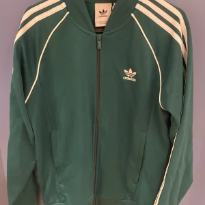 Grön träningsjacka från Adidas - säljer en grön adidas hoodie, andvänt 1 gång och glömde lämna tillbaka (ny pris 800)