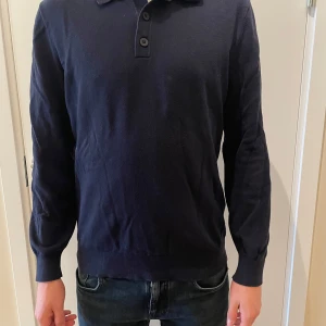 Mörkblå pikétröja från Massimo Dutti - Mörkblå pikétröja från Massimo Dutti i storlek S och modellen är 180 cm. Perfekt för både vardag och lite mer uppklädda tillfällen och passar perfekt med en skjorta eller en T-shirt 