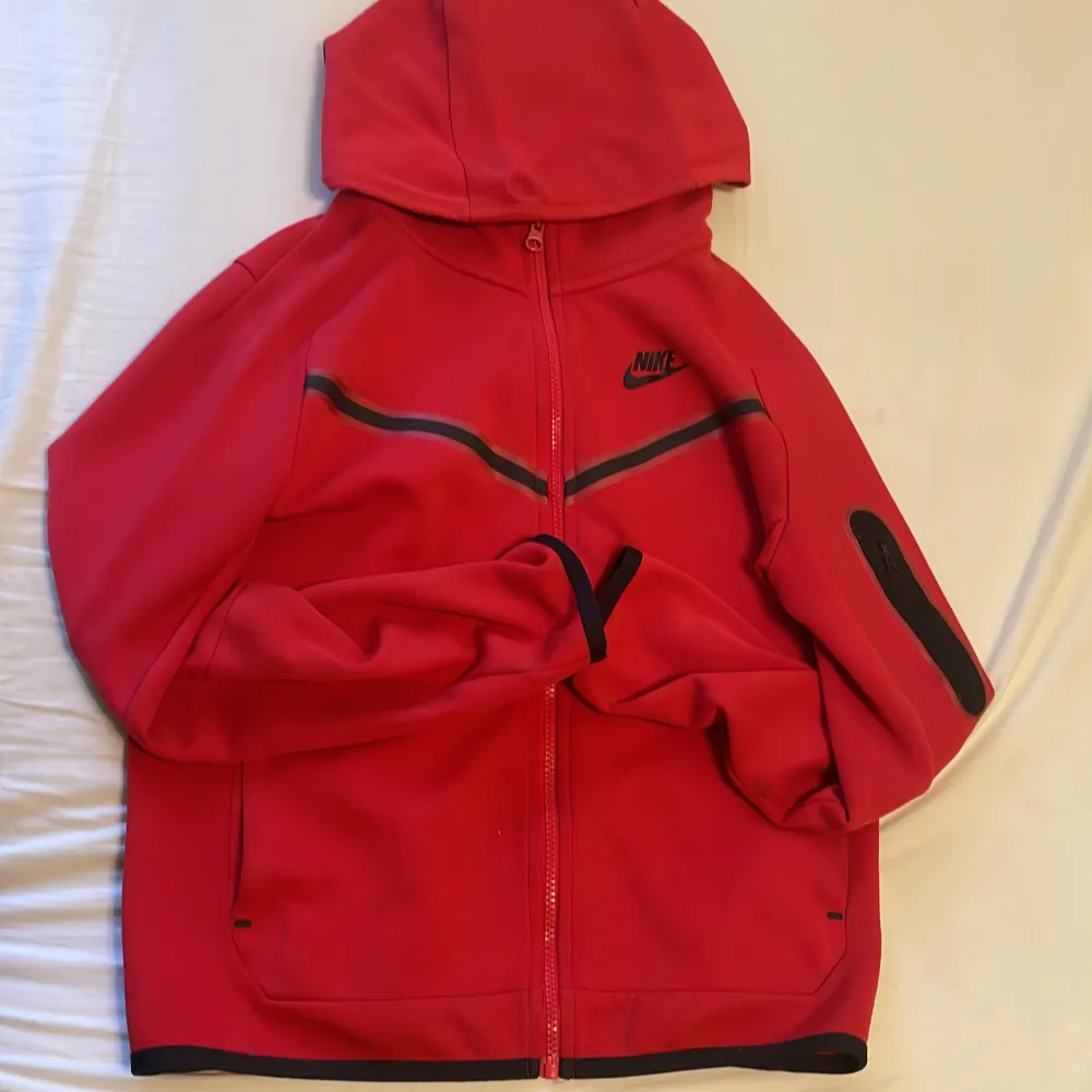 Säljer en Nike tech fleece i storlek L. Den har en dragkedja framtill och en cool svart detalj på ärmen. Perfekt för höst och vår, och den är superbekväm med sin långa ärmar och huva. Passar perfekt för både träning och chill. den passar bäst barn.. Jackor.