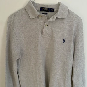 Grå pikétröja från Ralph Lauren - Säljer en fet grå pikétröja från Ralph Lauren i storlek S. Knappast använd, inga märken och är ser helt ny ut. Nypris runt 1499, köp för endast 399. Skriv gärna vid minsta lilla fundering!