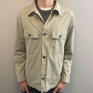 NN07 overshirt - Skön beige overshirt från NN07 i nyskick, aldrig använd. Storlek M, nypris runt 1800. Skriv för fler funderingar!