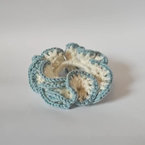 Handgjord virkad scrunchie i blått och vitt - Superfin handgjord scrunchie som är virkad i en härlig kombination av blått och vitt. Perfekt för att ge din frisyr en söt och unik touch. Den är elastisk och passar de flesta hårtyper. Perfekt accessoar för både vardag och fest!