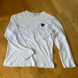 Comme des Garçons Tröja - En långärmad tunn Comme des Garçons tröja i vit med svart märke. Storlek M men sitter mer som S. Nypris över 1500kr, mitt pris 549kr. Väldigt bra skick, 9/10, knappt använd. Skriv vid minsta fundering😁