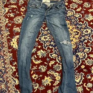Lågmidjade hollisterjeans - W 27, L 35. Rippade lågmidjade jeans med lite bootcut. 