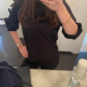 Svart tröja med trekvartsärm - Snygg svart tröja med trekvartsärm och rund hals. Perfekt för en stilren look. Passar bra till både jeans och kjol.