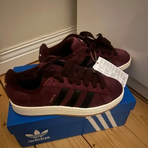 Vinröda Adidas Campus 00 - Säljer ett par helt nya adidas campus i en ish mörkröd färg (lite missvisade färg på bild men finns även bild tagen med blixt) Säljer då det var för små🫶🏻