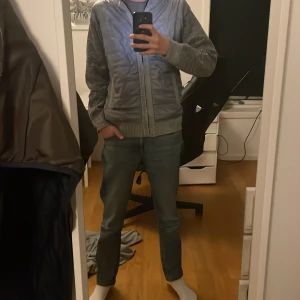 Grå cardigan - Säljer en grå cardigan pga för stor. Jackan har ribbstickade muddar och två fickor. Perfekt för kyligare dagar.