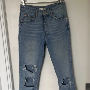 Blå jeans med slitningar - Snygga blå jeans med slitningar på knäna och råa kanter. Perfekta för en avslappnad stil. De har en klassisk femficksdesign och knappgylf. Sienna perfect jeans från Gina trico