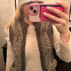 AFTERSKI Brun pälsväst - Säljer en mysig brun pälsväst i mycket bra skick. Perfekt för höst och vinter, med en stilren design som passar till många outfits. Västen har en normal passform och är superbekväm att bära över en tröja. Man kan knäppa den 