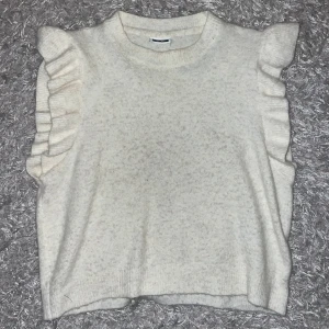 Vit stickad topp med volangdetaljer - Säljer en superfin vit stickad topp med volang på axlarna. 🩷Skriv för fler bilder 