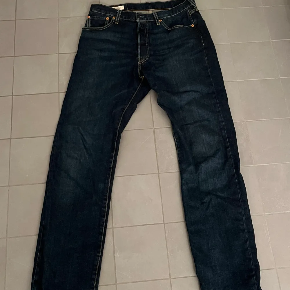 Säljer ett par klassiska Levi's 501 jeans i mörkblå denim. De har en rak passform och är i mycket bra skick. Perfekta för både vardag och fest! 🕺helt oanvända då jag köpte fel storlek. Går för runt 1000 nypris . Jeans & Byxor.