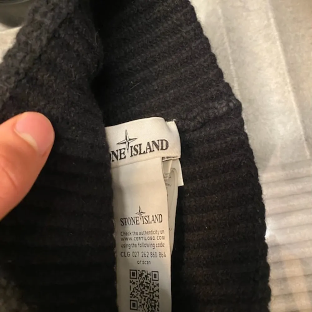 Säljer en snygg svart ribbad mössa från Stone Island. Den är i mycket bra skick och har en stilren design med en broderad logga framtill. Perfekt för höst och vinter för att hålla dig varm och trendig. Passar de flesta tack vare sin flexibla passform.. Accessoarer.