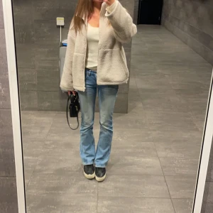 Beige teddyjacka - Mysig beige teddyjacka i oversized passform. Perfekt för höst och vinter med dragkedja framtill. Jackan är långärmad och gjord av ett mjukt teddy-material som håller dig varm och bekväm. Från Åhléns säljer för 450 