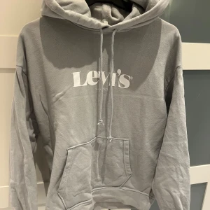 Grå hoodie från Levi's - Säljer en stilren grå/blå hoodie från Levi's