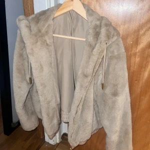 Beige teddyjacka med huva - Mysig beige teddyjacka med huva, perfekt för kyliga dagar. Jackan har dragkedja och ribbade muddar. Den är i bra skick (utöver det som hänt i luvan) storlek M