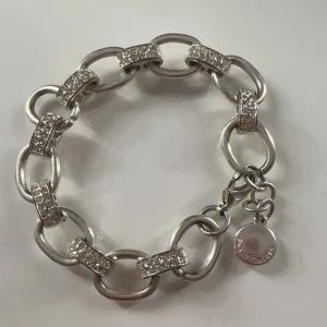 Silverfärgat armband med glittriga länkar - Silver pläterad på rostfritt stål!! Snyggt och stilrent armband i silverfärg med glittriga länkar. Perfekt för att ge lite extra bling till din outfit. Armbandet har en rund berlock som hänger vid låset. Passar både till vardags och festliga tillfällen. Priset kan diskuteras❤️❤️