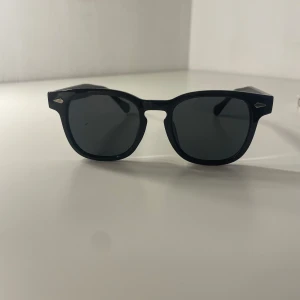 Svarta solglasögon från nordic smycken - Snygga svarta solglasögon i klassisk Wayfarer-stil. Perfekta för både vardag och fest. De har en robust ram och mörka linser som skyddar mot solen. Passar till alla outfits och ger en cool look. Ett måste för sommaren! 😎oanvänd