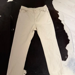 Beige byxor från Lindex - Säljer ett par stilrena beige byxor från Lindex. De har en klassisk design med normal passform och är tillverkade i ett bekvämt material. Perfekta för en avslappnad look.